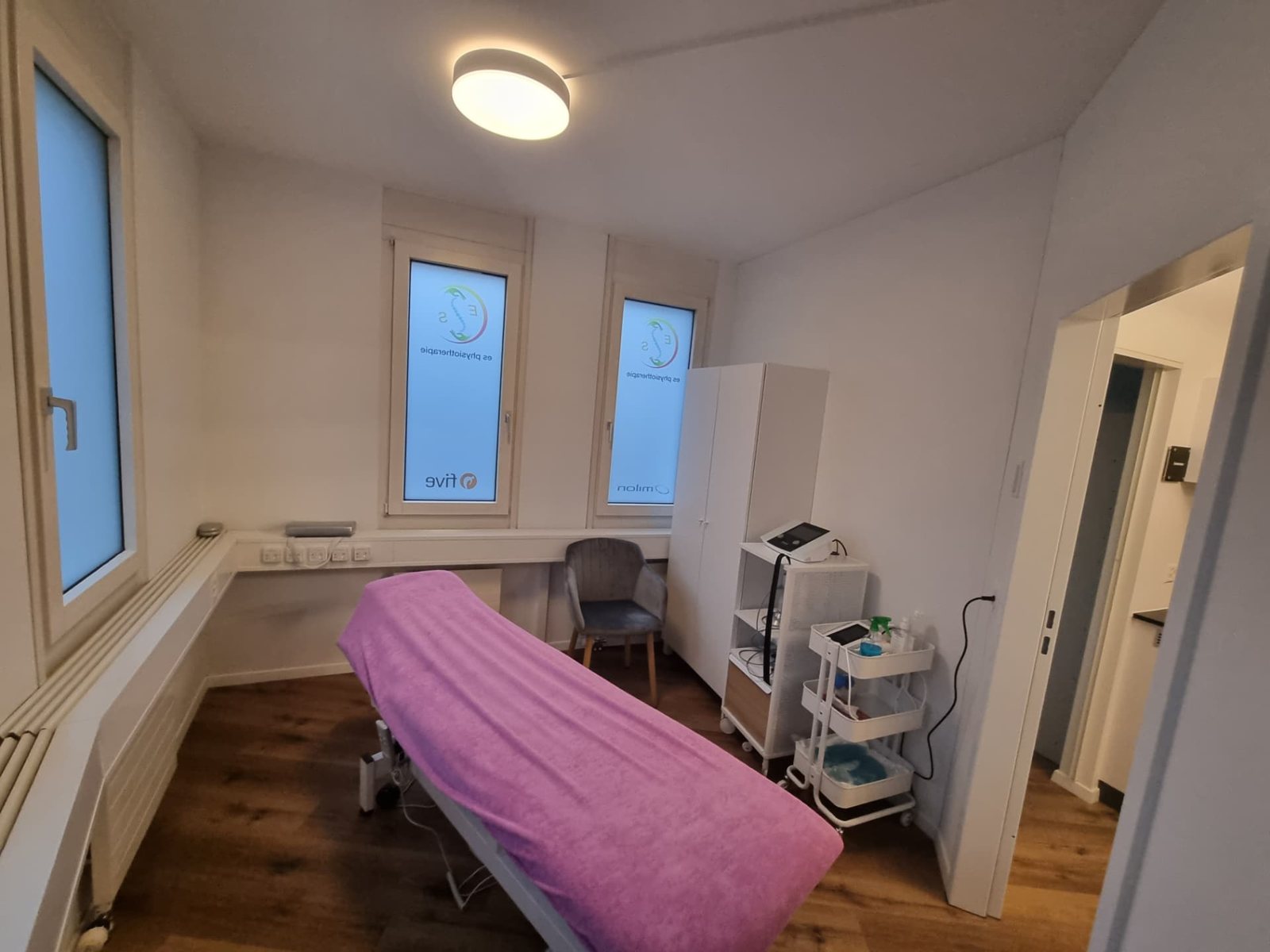 Behandlungsraum mit violett bezogener Therapieliege in Geroldswil